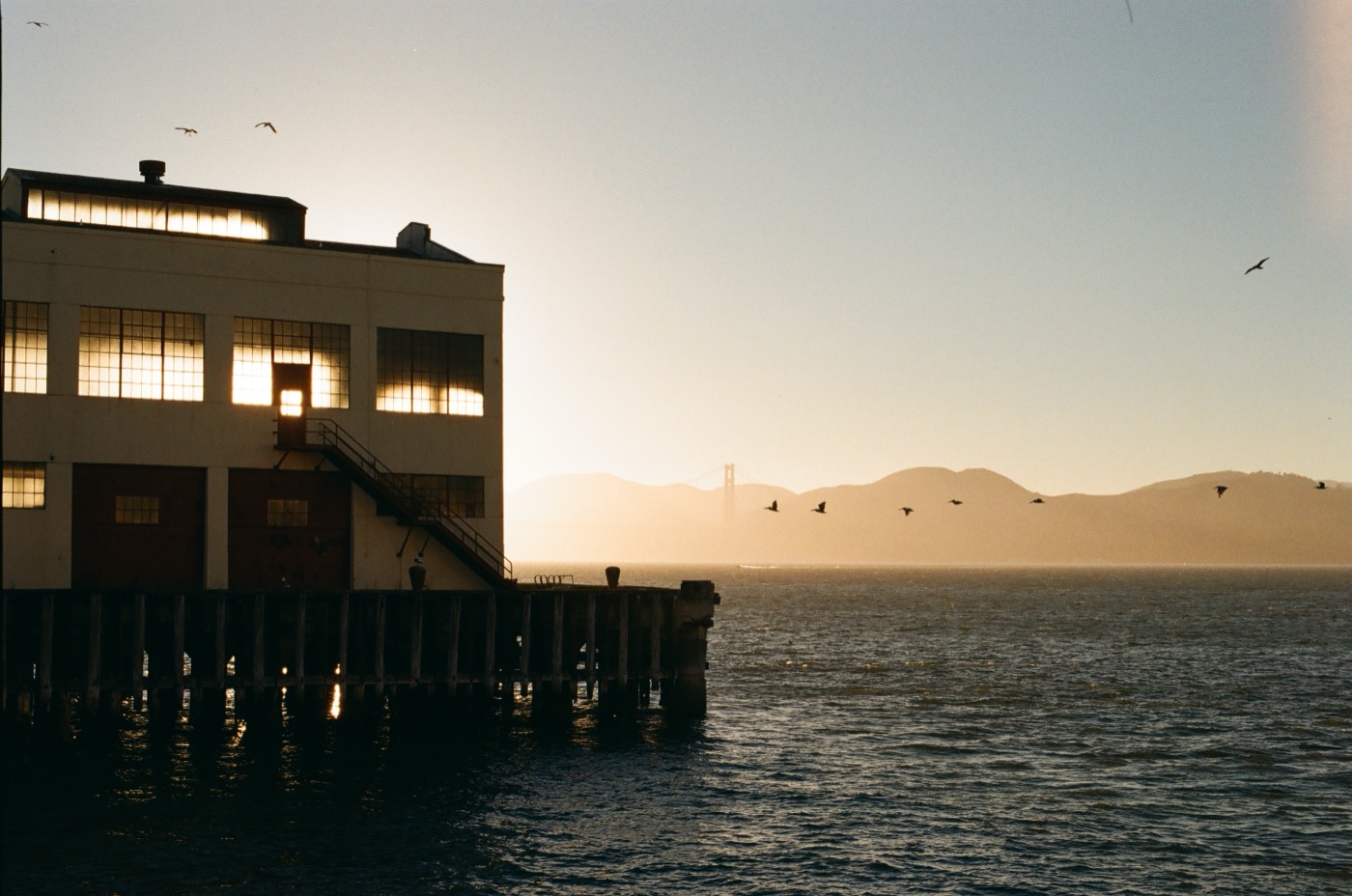 Waterfront pier at dusk with mountains in the background
